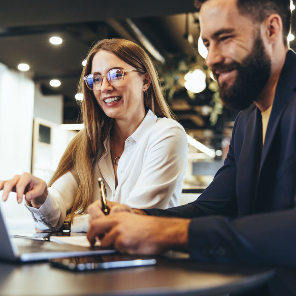 Cheerful businesspeople using a laptop in an office