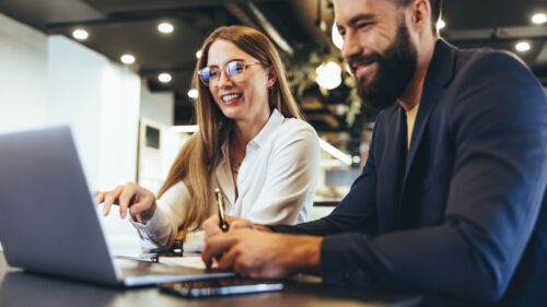 Cheerful businesspeople using a laptop in an office