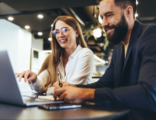 Cheerful businesspeople using a laptop in an office